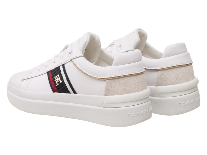 Tenis blancos Tommy Hilfiger de corte bajo con franja lateral tricolor y detalle beige en el talón.