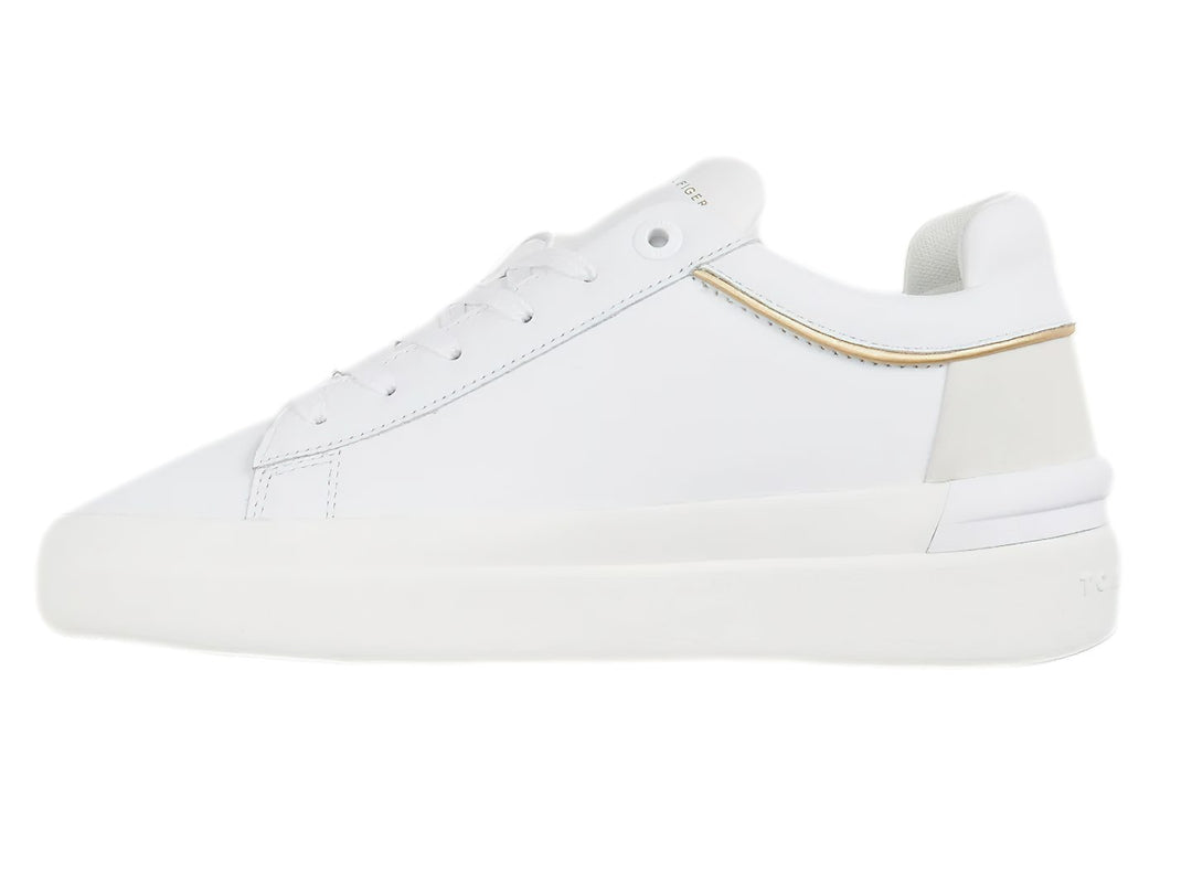 Tenis blancos Tommy Hilfiger de corte bajo con franja lateral tricolor y detalle beige en el talón.