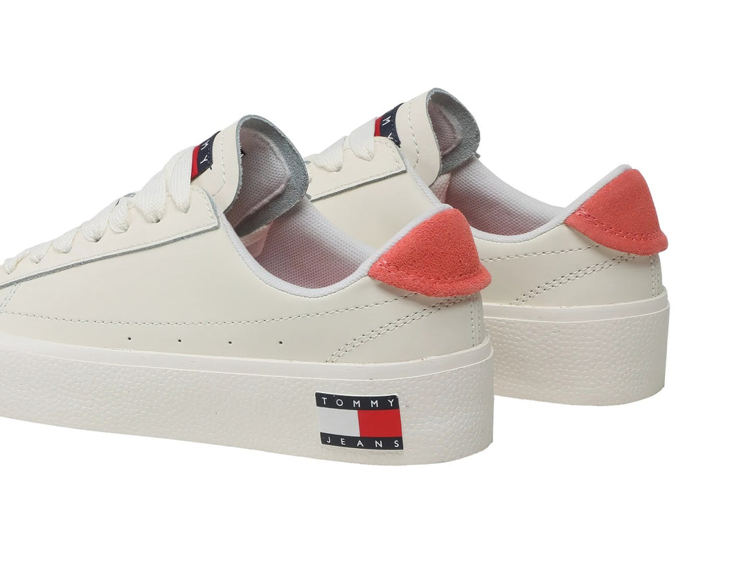 Tenis blancos de cuero con suela de plataforma y detalle en color rosa palo en el talón.
