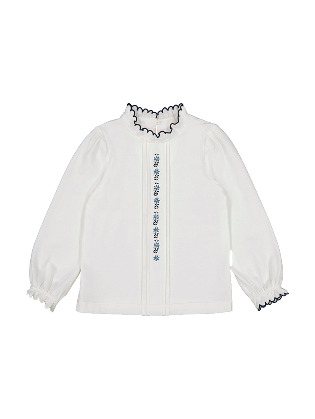 Blusa blanca de manga larga con bordados azules centrales y detalles ondulados en cuello y puños.