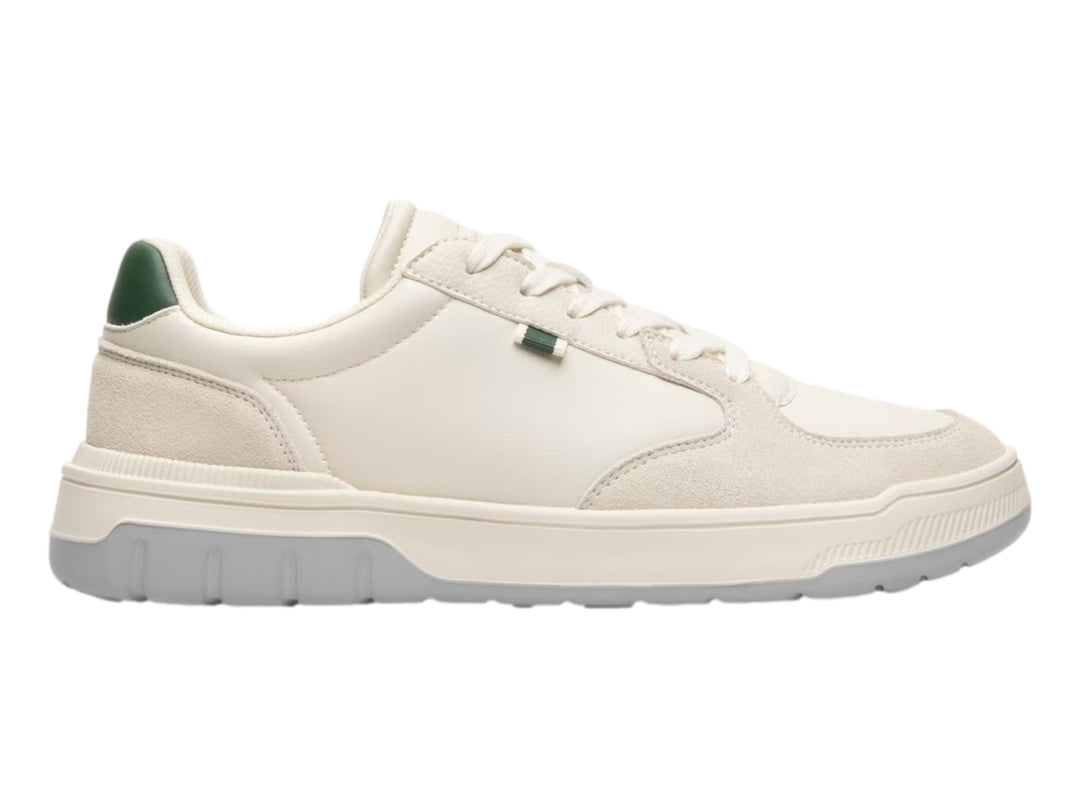 Tenis Flexi color beige con suela gris y pequeños detalles verdes en el talón y la lengüeta.