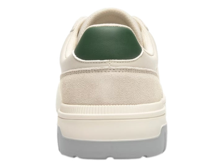 Tenis Flexi color beige con suela gris y pequeños detalles verdes en el talón y la lengüeta.