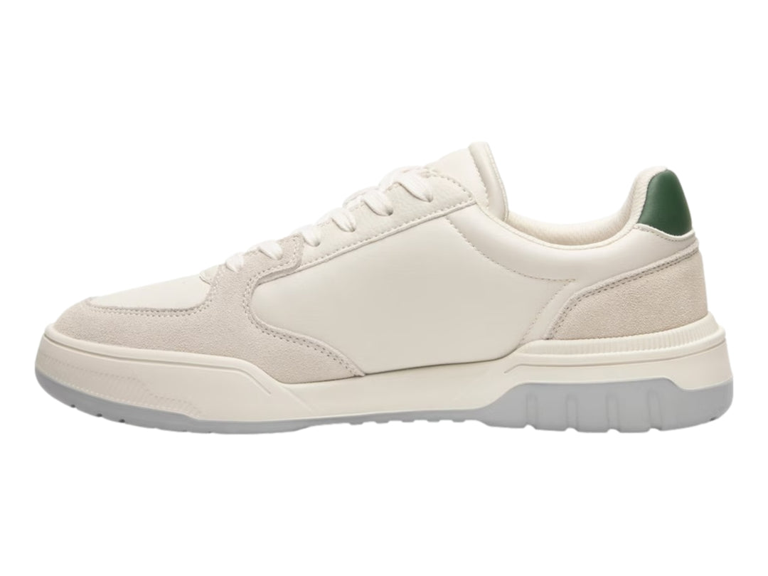 Tenis Flexi color beige con suela gris y pequeños detalles verdes en el talón y la lengüeta.