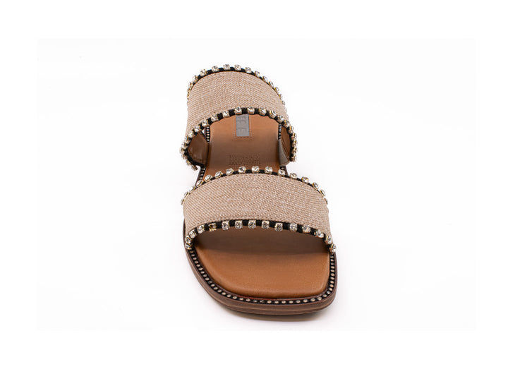 Sandalias slide color crudo con dos bandas decoradas con tachuelas y suela marrón.