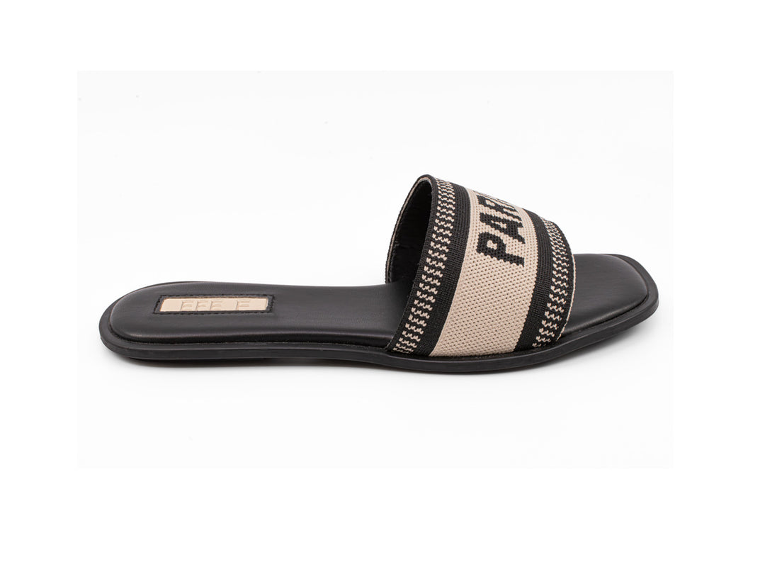 Sandalia deslizable color negro con banda beige y detalles en negro sobre fondo blanco.