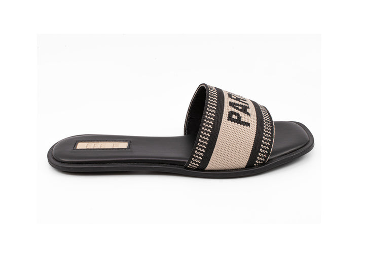 Sandalia deslizable color negro con banda beige y detalles en negro sobre fondo blanco.