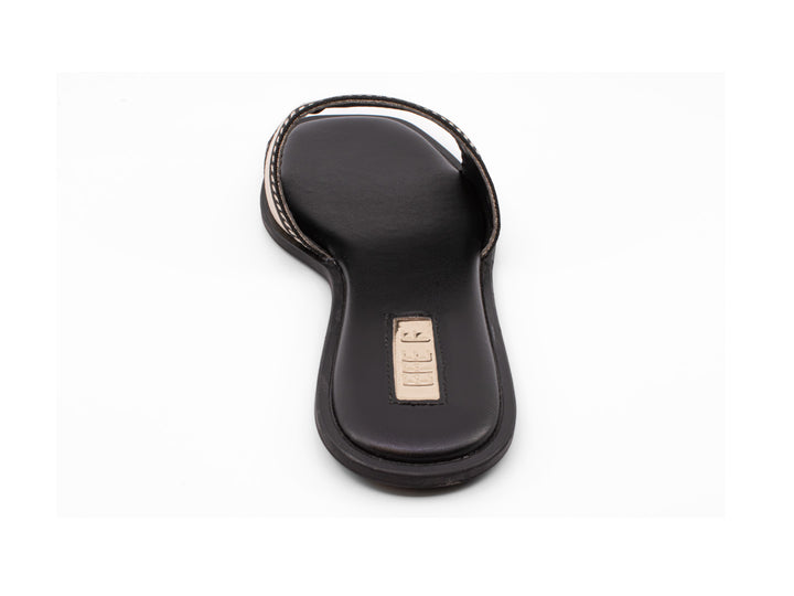 Sandalia deslizable color negro con banda beige y detalles en negro sobre fondo blanco.