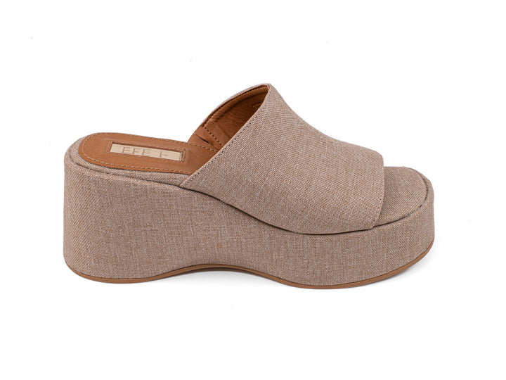 Sandalia de plataforma color crudo con acabado textil y suela café para mujer.