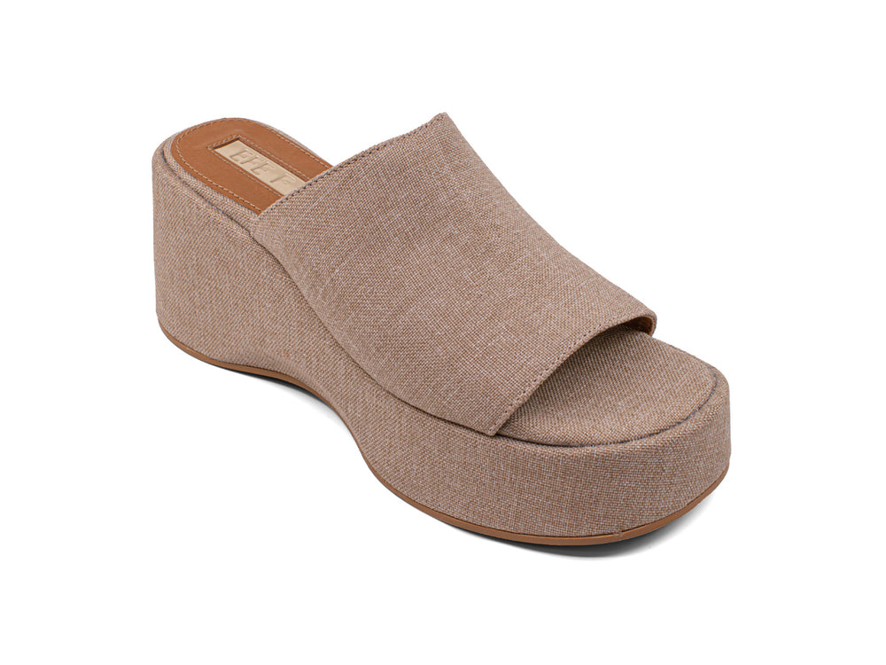 Sandalia de plataforma color crudo con acabado textil y suela café para mujer.