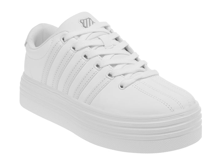 Tenis K-Swiss color blanco con suela de plataforma alta y diseño clásico deportivo.