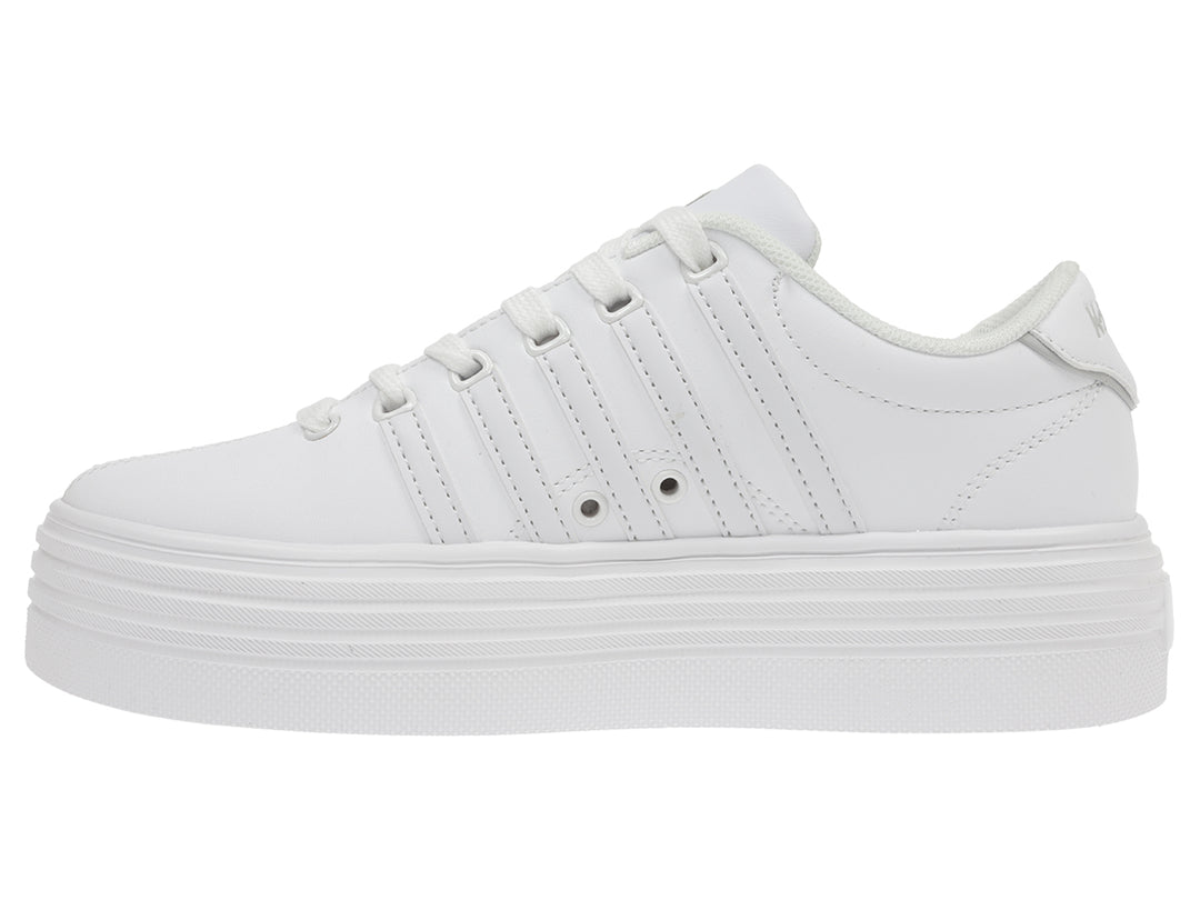 Tenis K-Swiss color blanco con suela de plataforma alta y diseño clásico deportivo.