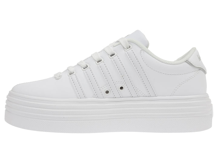 Tenis K-Swiss color blanco con suela de plataforma alta y diseño clásico deportivo.