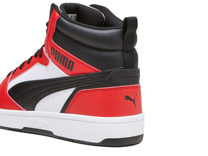 Tenis PUMA Rebound V6 de cuello alto en colores blanco, rojo y negro con suela blanca.