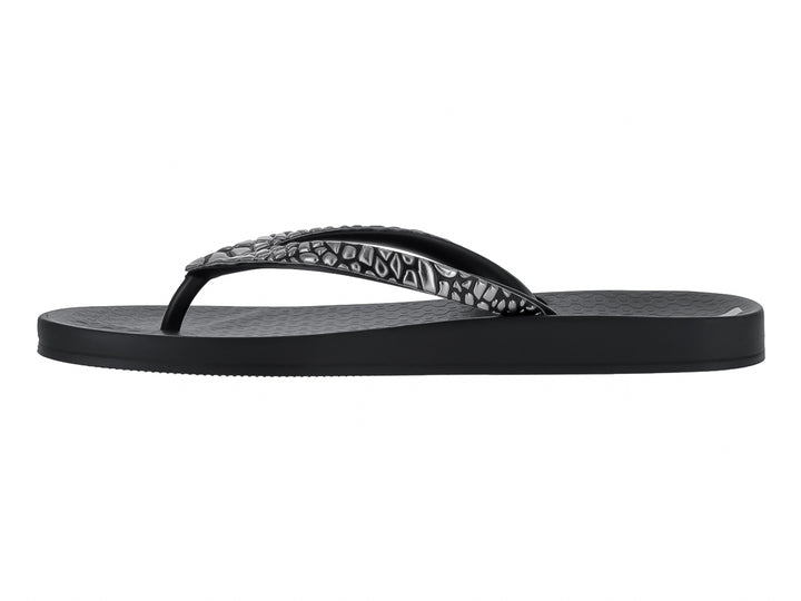 Sandalias negras Ipanema con correa texturizada en color gris y suela plana.