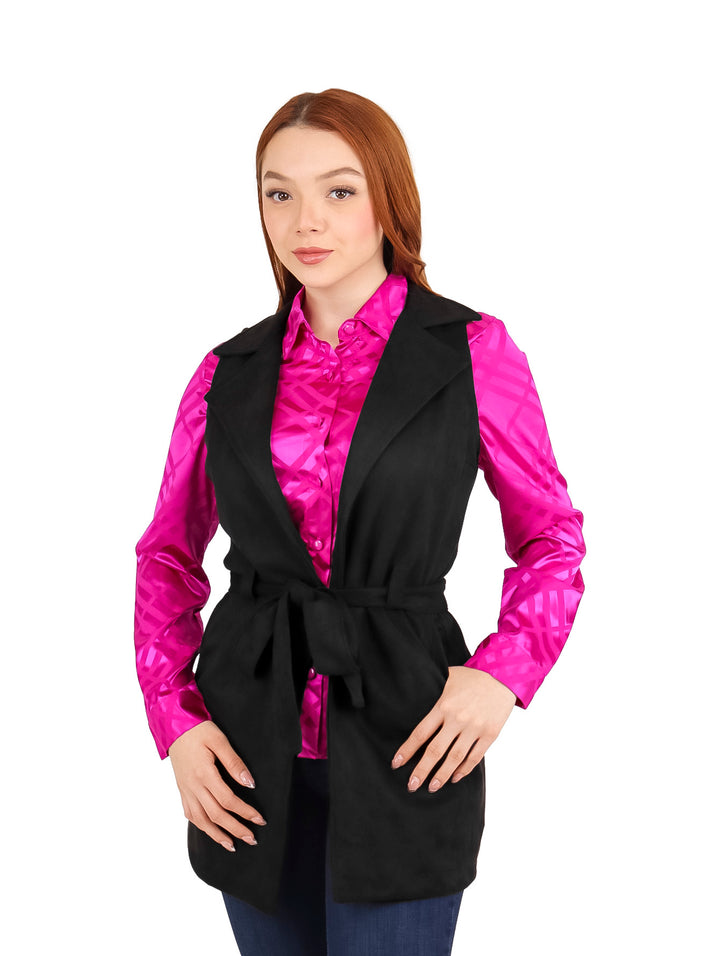 Mujer vistiendo un chaleco largo negro de gamuza con cinturón sobre una camisa rosa.