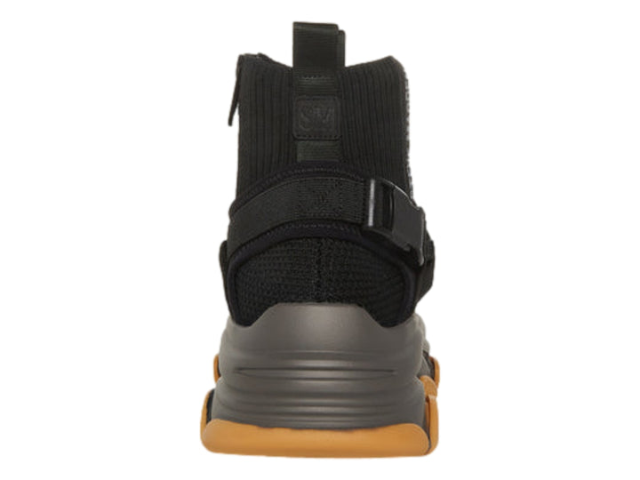 Tenis Steve Madden color negro y gris oscuro con suela gruesa color caramelo y correas negras.