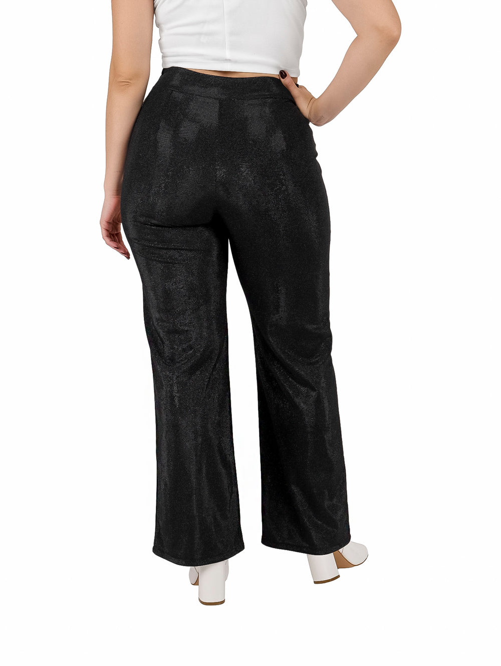 Mujer vistiendo pantalón ancho color negro con efecto de brillos y talle alto.
