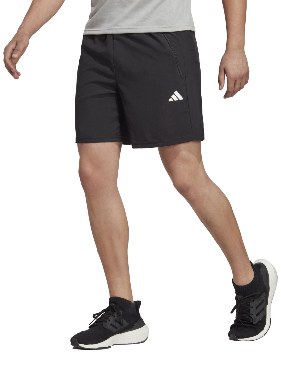 Hombre vistiendo shorts deportivos Adidas de color negro con logo blanco en la pierna izquierda.