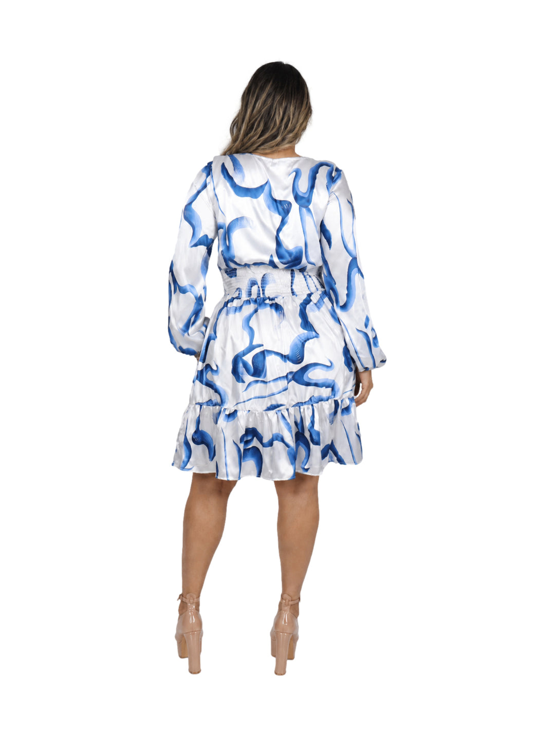 Mujer vistiendo un vestido corto de satín blanco con estampado abstracto en azul, mangas largas y volante inferior.