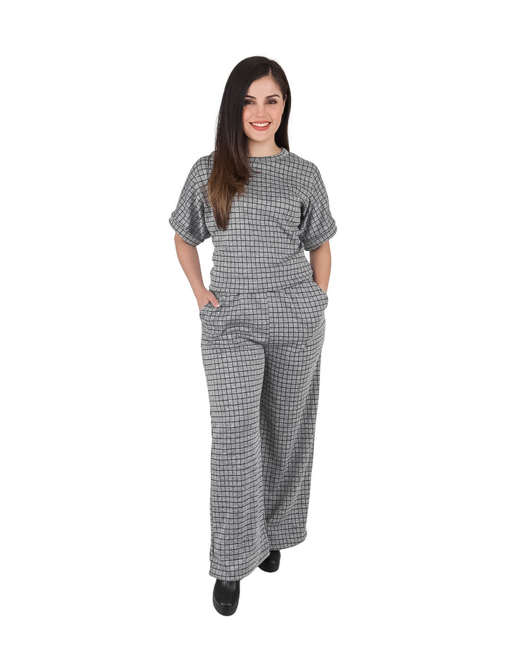 Mujer vistiendo un conjunto de dos piezas color gris con estampado de cuadros, compuesto por blusa y pantalón ancho.