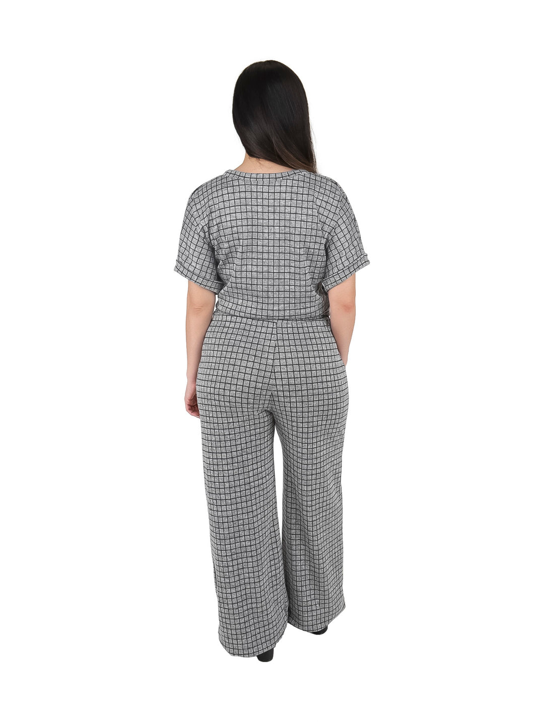 Mujer vistiendo un conjunto de dos piezas color gris con estampado de cuadros, compuesto por blusa y pantalón ancho.