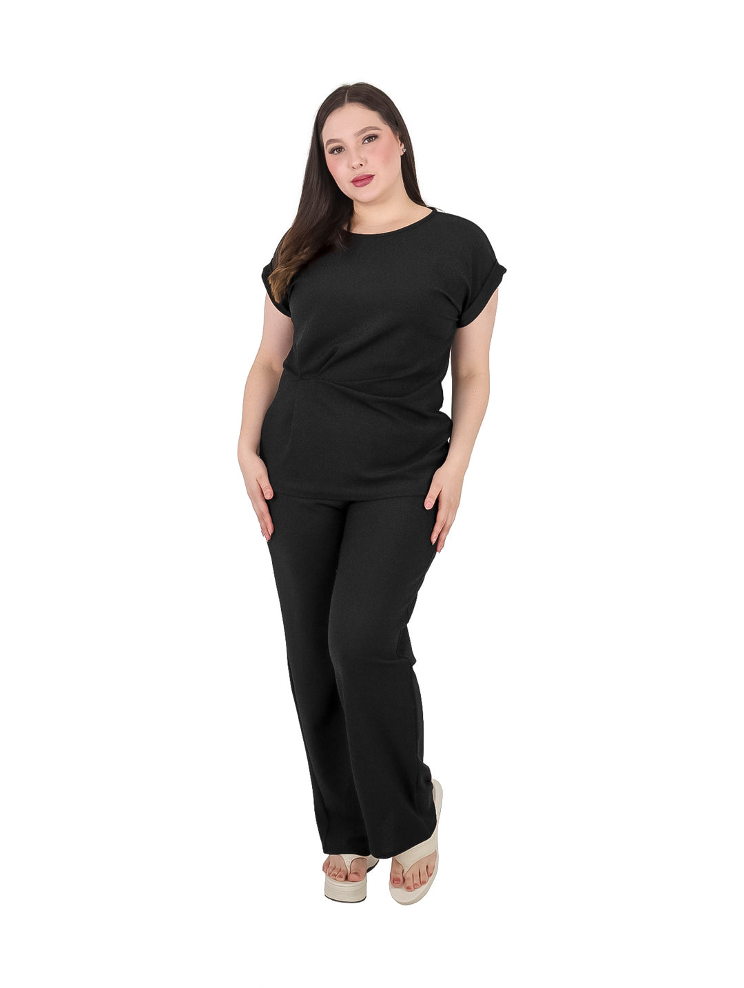Mujer vistiendo un conjunto de dos piezas en color negro compuesto por playera y pantalón.