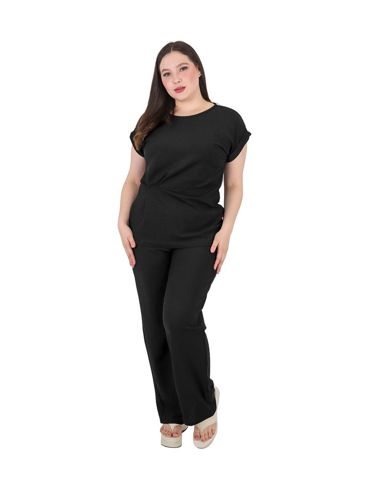 Mujer vistiendo un conjunto de dos piezas en color negro compuesto por playera y pantalón.