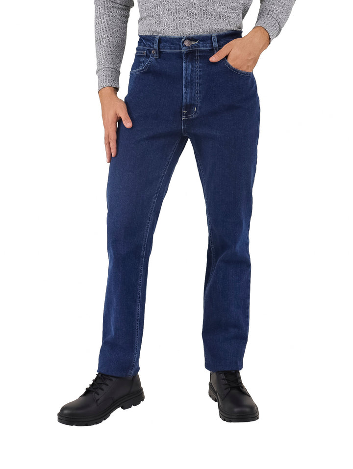Hombre vistiendo pantalones jeans de color azul oscuro y zapatos negros.