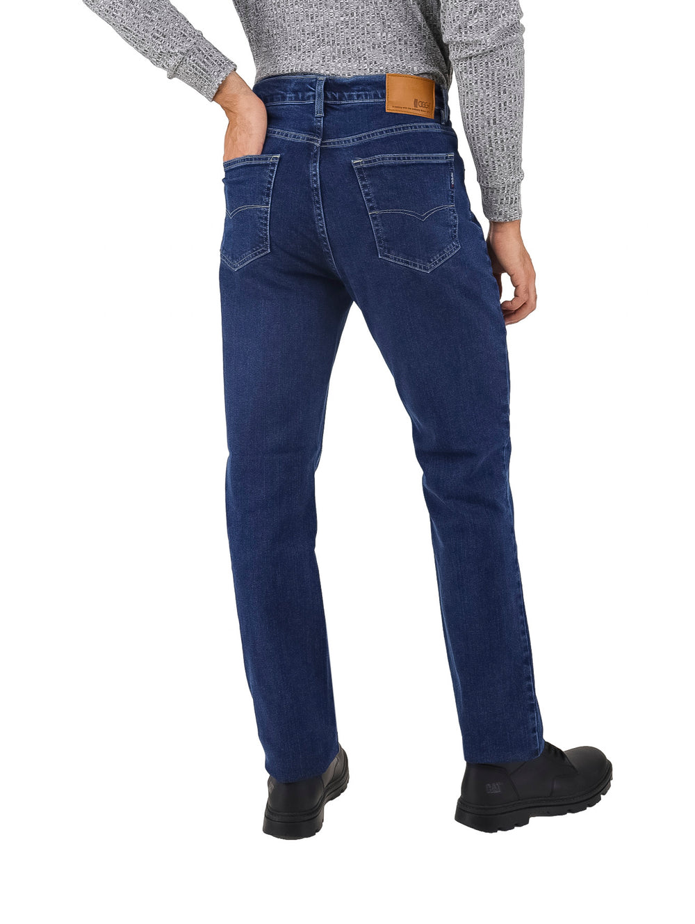 Hombre vistiendo pantalones jeans de color azul oscuro y zapatos negros.