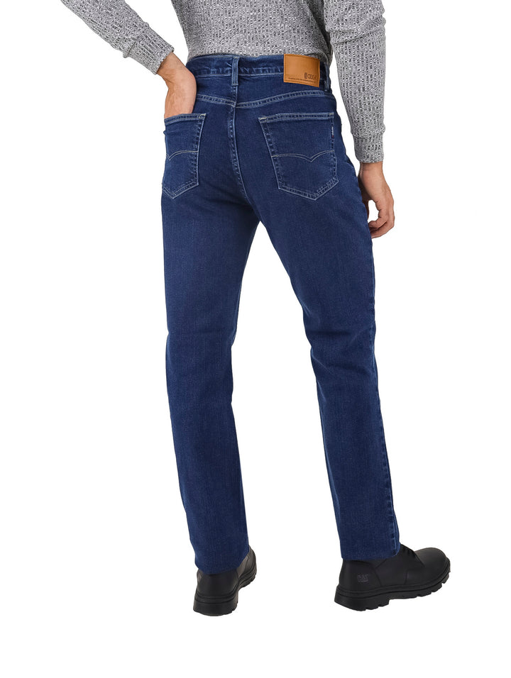 Hombre vistiendo pantalones jeans de color azul oscuro y zapatos negros.