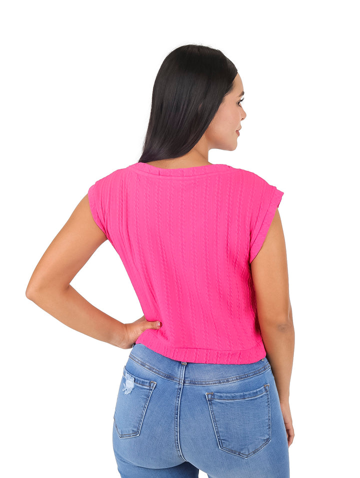 Mujer vistiendo blusa corta color fucsia sin mangas con cuello en V y pantalones vaqueros azules.