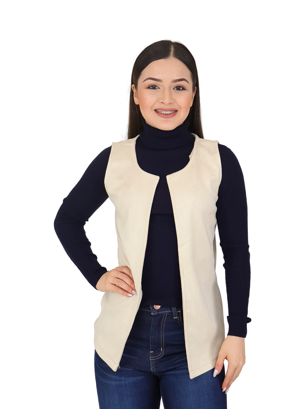 Mujer vistiendo un chaleco largo color hueso sobre un suéter negro y jeans azules.