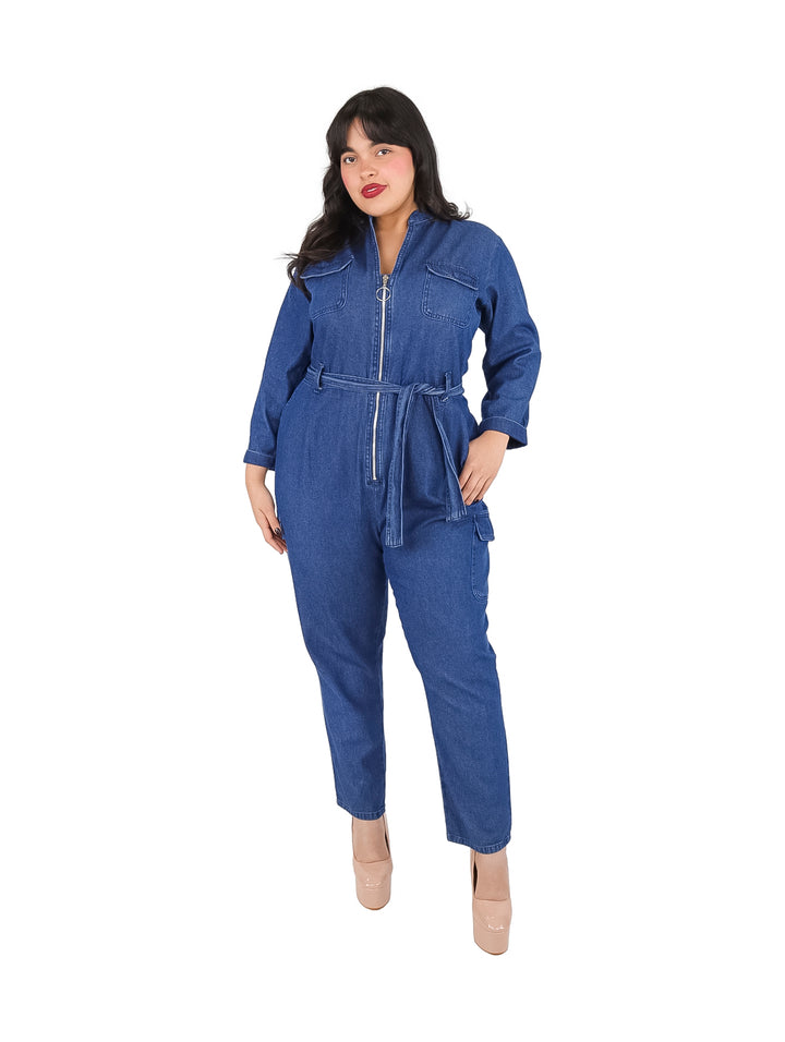 Mujer vistiendo un overol azul stone blue con cierre frontal y cinturón ajustable en la cintura.