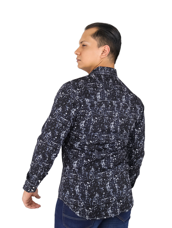 Hombre vistiendo camisa negra de manga larga con estampado blanco y jeans azules.
