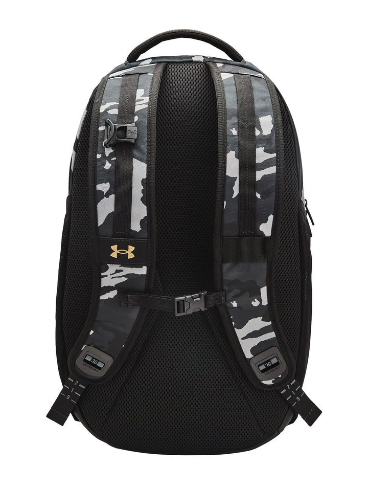 Mochila Under Armour Hustle Pro con estampado de camuflaje en tonos negro y gris con detalles en dorado.
