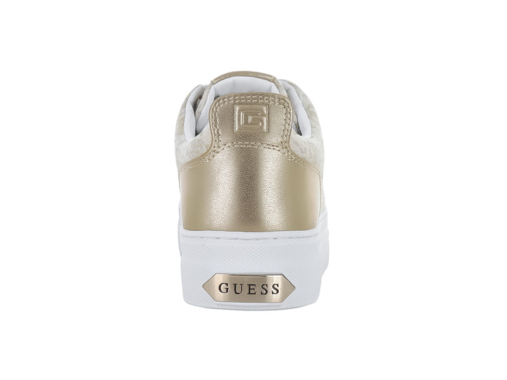Tenis Guess de tela beige con estampado, talón dorado y suela blanca.