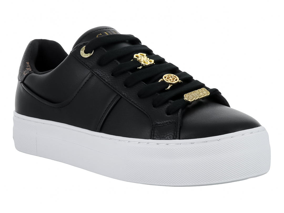 Tenis negros GUESS con suela blanca ancha y detalles decorativos dorados en las agujetas.