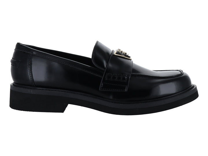 Zapato tipo mocasín Guess en color negro brillante con hebilla dorada y suela gruesa.