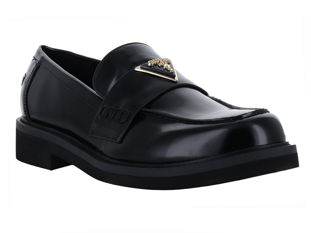 Zapato tipo mocasín Guess en color negro brillante con hebilla dorada y suela gruesa.