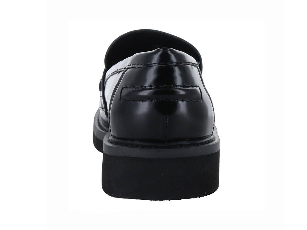 Zapato tipo mocasín Guess en color negro brillante con hebilla dorada y suela gruesa.