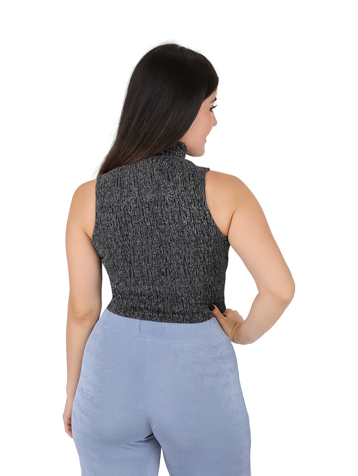 Mujer vistiendo blusa plateada brillante sin mangas con cuello alto y corte crop.