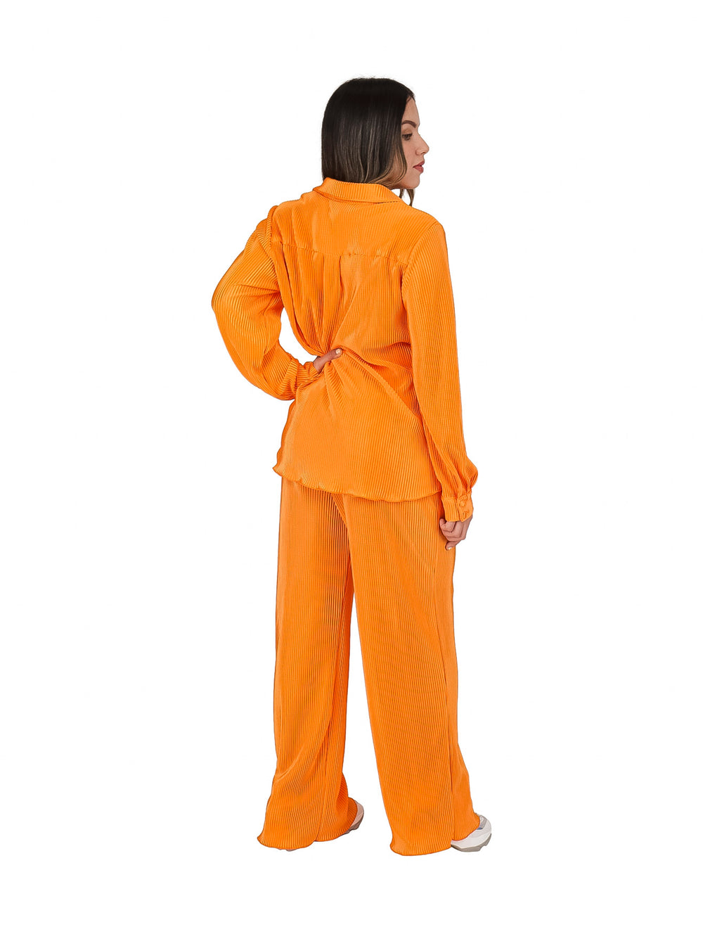 Mujer vistiendo un conjunto de dos piezas color naranja compuesto por blusa camisera y pantalón plisado.
