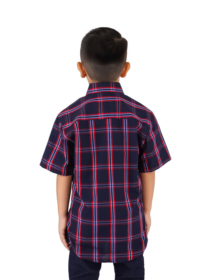 Niño vistiendo camisa de manga corta con estampado de cuadros en colores rojo y marino.