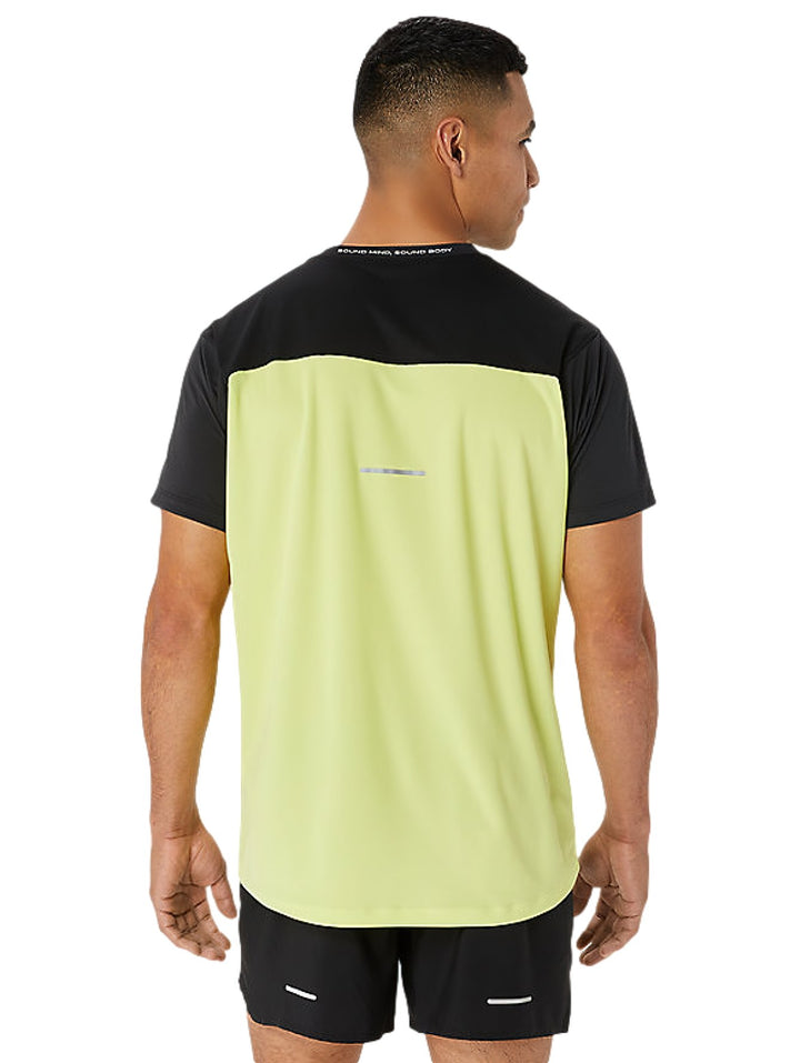 Hombre vistiendo camiseta deportiva ASICS en colores negro y amarillo brillante con shorts negros.