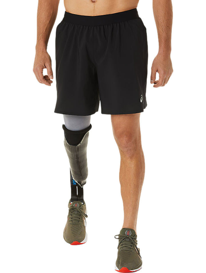 Hombre vistiendo shorts deportivos negros de la marca ASICS.