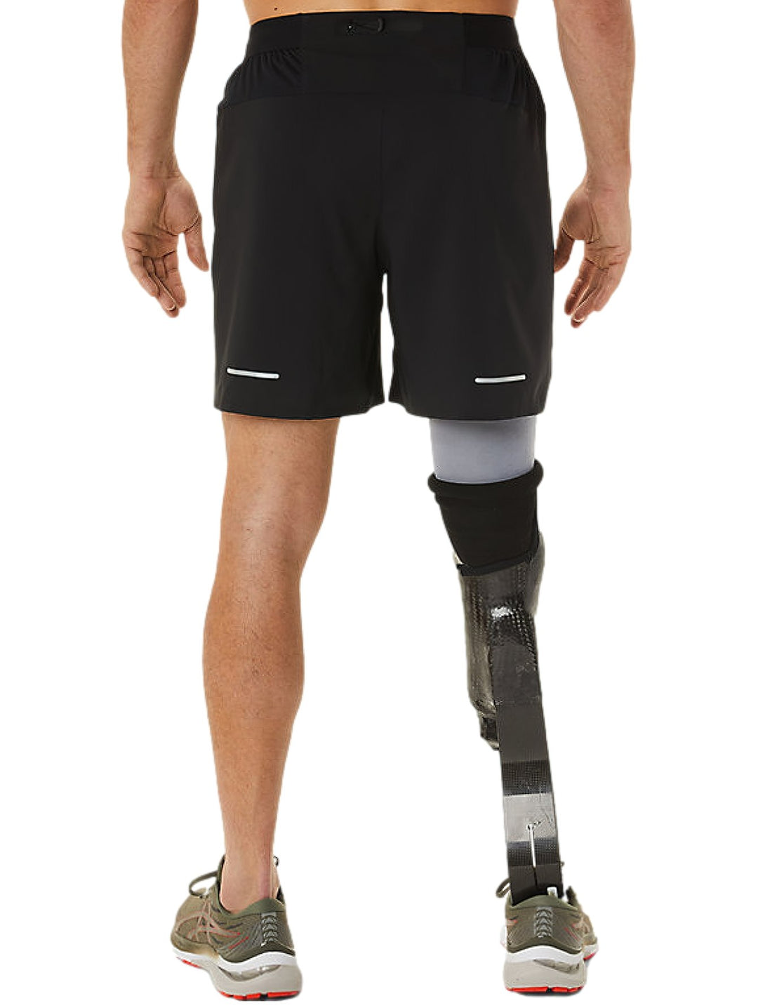 Hombre vistiendo shorts deportivos negros de la marca ASICS.