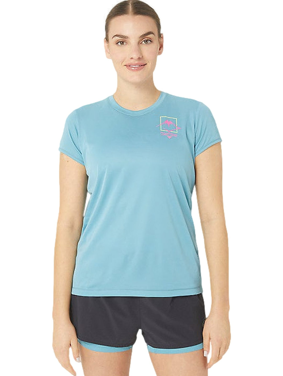 Mujer vistiendo camiseta deportiva ASICS de color azul grisáceo con logo en el pecho y shorts oscuros.