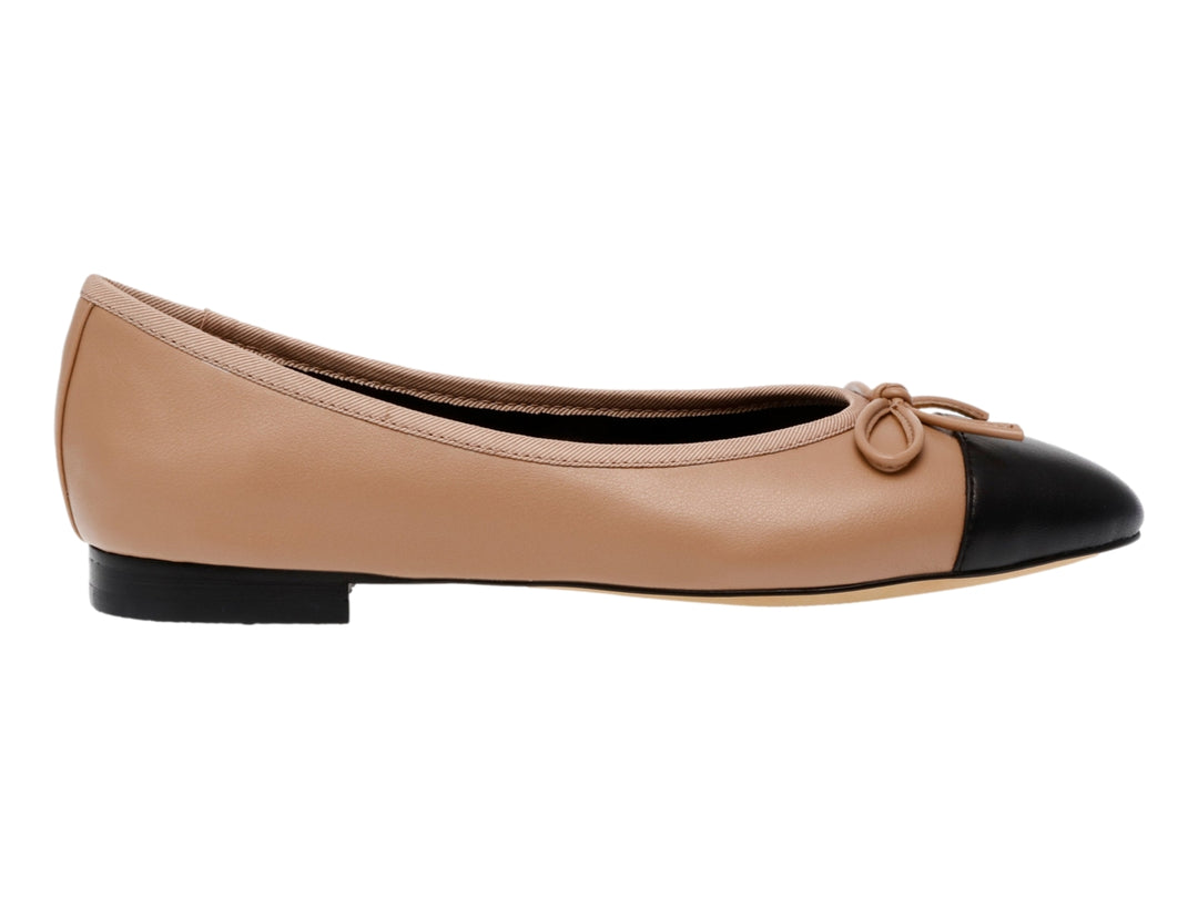 Zapatos planos Steve Madden color tan con punta negra y detalle de moño pequeño en la parte superior.