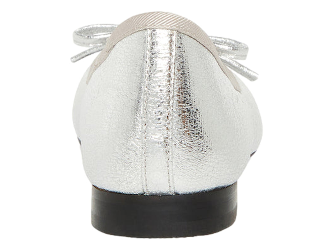 Zapato plano color plata metálico con punta negra y detalle decorativo superior.