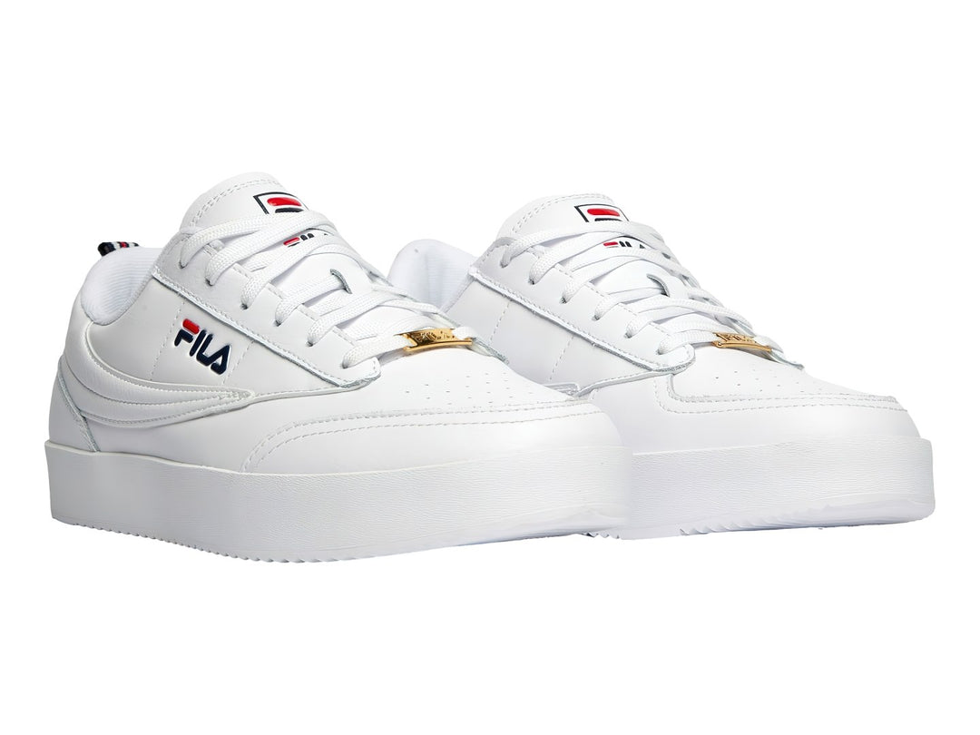 Tenis FILA blancos de corte bajo con suela gruesa y logotipo lateral en colores azul y rojo.